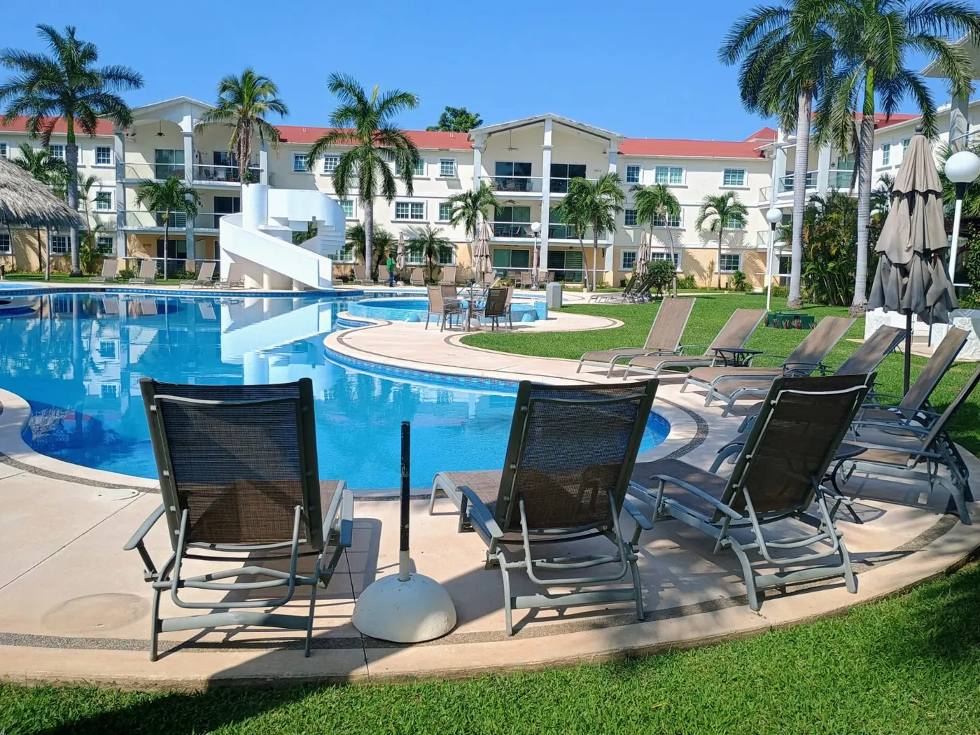 Camastros y sillones junto a la alberca